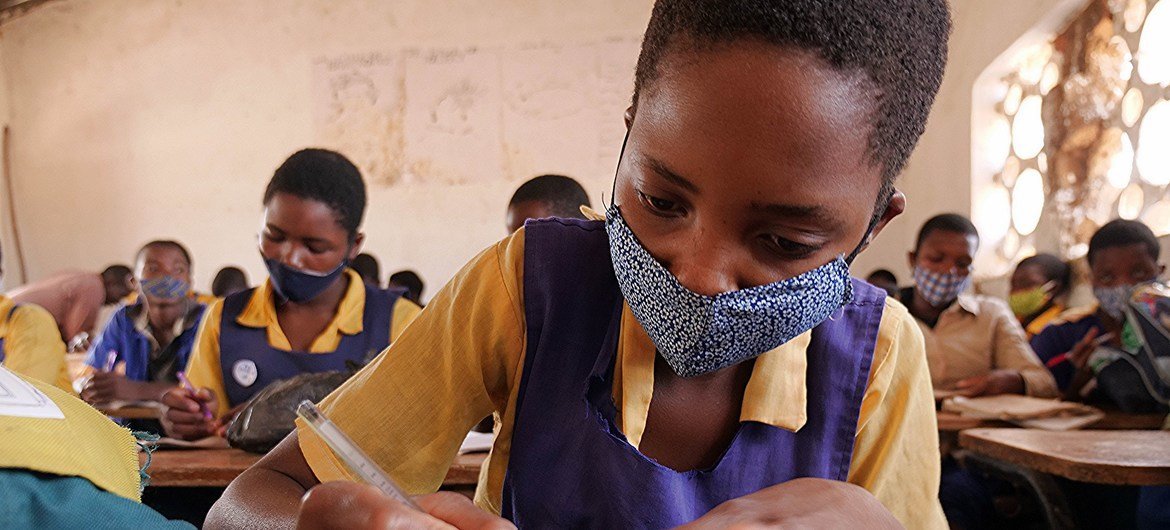 Une enfant se concentre sur son devoir de classe tout en respectant les normes sanitaires  à l’école primaire Mchoka dans le district de Salima, au Malawi , le 13 Novembre, 2020.