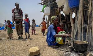 埃塞俄比亚阿法尔，一位流离失所的母亲为家人做饭。