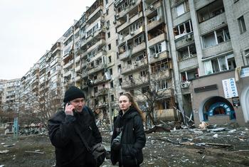 في 25 شباط/فبراير 2022 في كييف بأوكرانيا ، اتصل رجل بأقاربهم وهم يقفون أمام مبنى سكني تضرر بشدة خلال العمليات العسكرية الجارية.