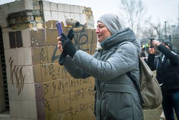 On 25 February 2022 in Kyiv, Ukraine, a resident photographs her apartment building, which was heavily damaged during ongoing military operations