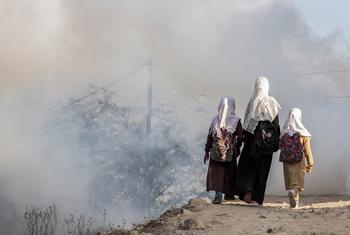 Três irmãs caminham para escola perto de zona de combate no Iêmen, em 2021