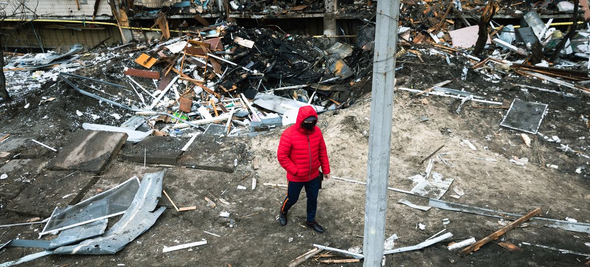 Un homme marche devant un cratère créé par une explosion à Kyïv, en Ukraine.