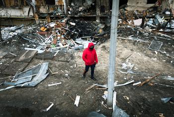 Un homme marche devant un cratère créé par une explosion à Kyïv, en Ukraine.