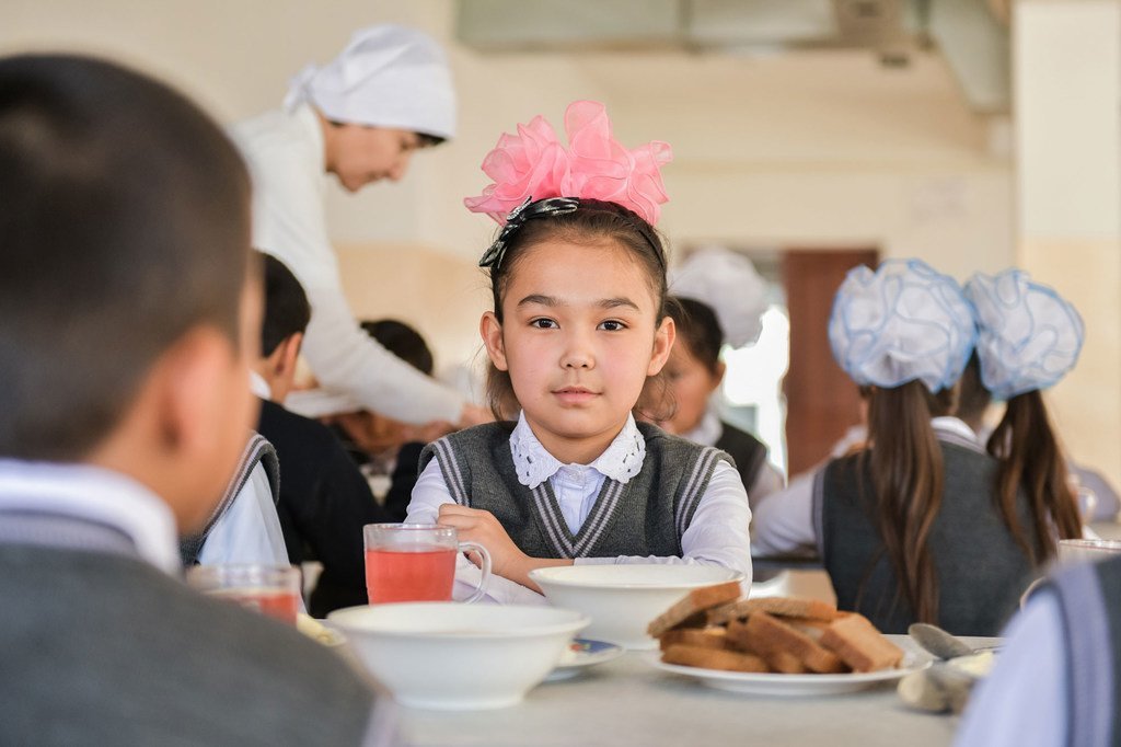 طفلة في 9 من عمرها تحصل على وجبة الغذاء في مدرستها الابتدائية في مدينة تركستان في كزاخستان.