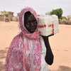  Une réfugiée sud-soudanaise reçoit du savon d'un centre de distribution du HCR dans un camp du Sud Darfour.