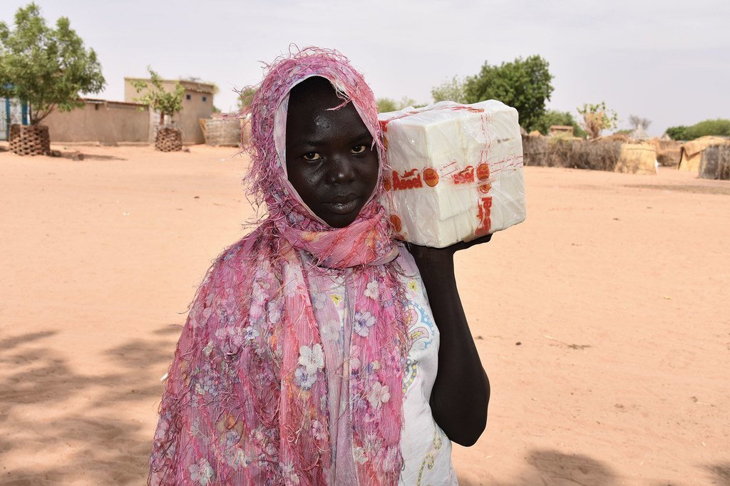  Une réfugiée sud-soudanaise reçoit du savon d'un centre de distribution du HCR dans un camp du Sud Darfour.