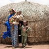 Une femme et ses fils se tiennent devant leur abri dans un camp de déplacés à Baboua, en République centrafricaine.