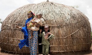A woman and her young sons stand in front of their shelter in a camp for displaced people in Baboua, Central African Republic.