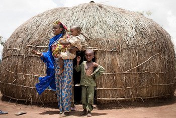 A woman and her young sons stand in front of their shelter in a camp for displaced people in Baboua, Central African Republic.