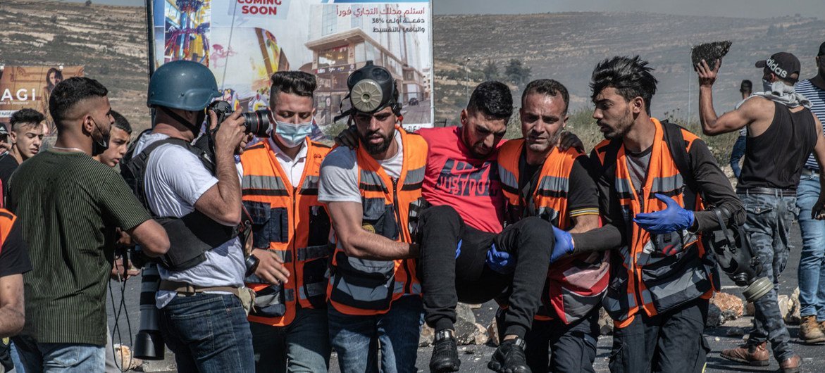(من الأرشيف) عاملو إغاثة يساعدون رجلا أصيب في رام الله بالضفة الغربية.