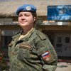Российская женщина-миротворец, капитан Евгения, стоит в военной форме перед зданием штаб-квартиры ООН .