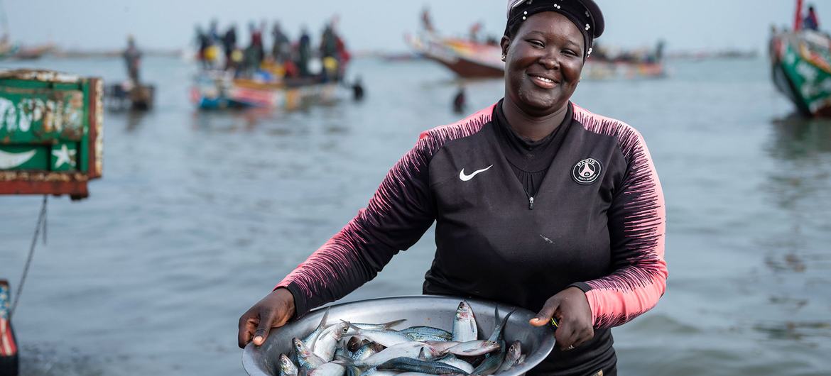 Une pêcheuse en route pour vendre le poisson qu'elle a pêché au port de Joal au Sénégal.