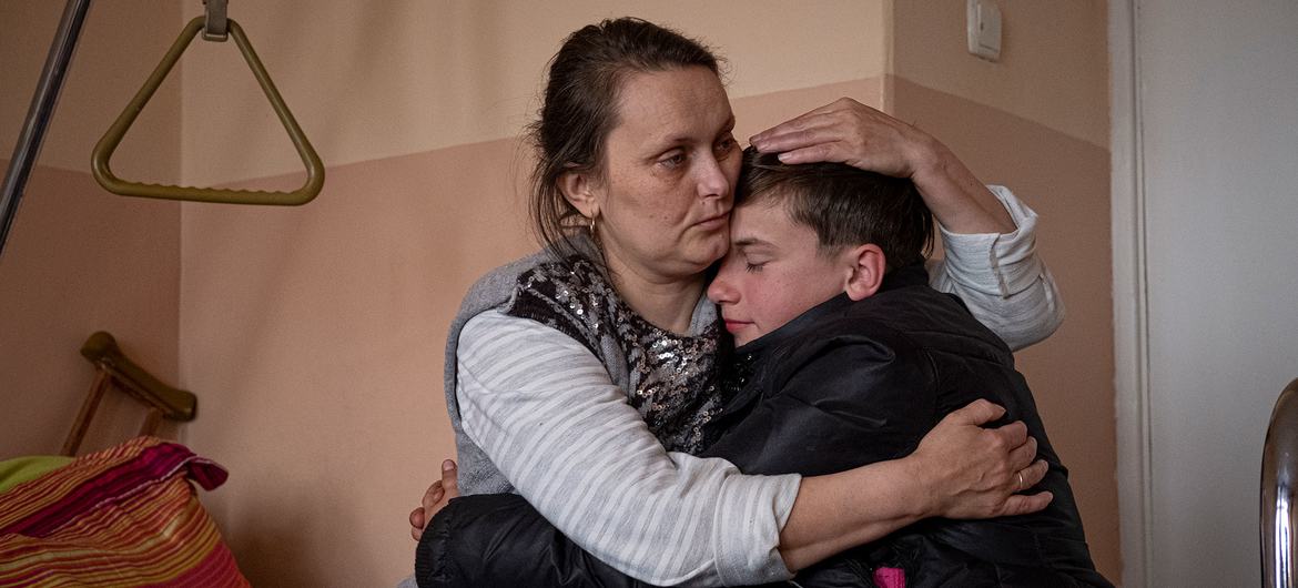 Un garçon de douze ans rend visite à sa mère à l'hôpital pour la première fois depuis qu'elle a été blessée il y a un mois par des éclats d'obus.