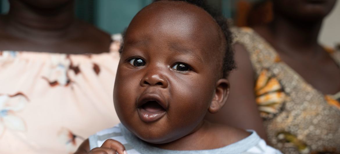 4 महीने का अमीन मुक्तर, दक्षिण सूडान के जुबा में न्याकुरोन प्राथमिक स्वास्थ्य देखभाल केंद्र में पोलियो और पेंटावैलेंट टीके प्राप्त करने की प्रतीक्षा करते हुए, अपनी माँ की गोद में बैठा है.