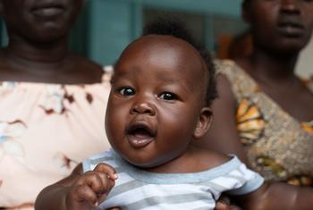 4 महीने का अमीन मुक्तर, दक्षिण सूडान के जुबा में न्याकुरोन प्राथमिक स्वास्थ्य देखभाल केंद्र में पोलियो और पेंटावैलेंट टीके प्राप्त करने की प्रतीक्षा करते हुए, अपनी माँ की गोद में बैठा है.