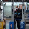 رجل يرتدي القناع والقفازات لدى مروره عبر أحد محطات القطار في مدينة نيويورك مع استمرار تفشي جائحة كوفيد-19.