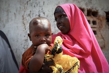 امرأة وطفلها الصغير ينتظران خارج عيادة طبية مجانية في كيسمايو ، الصومال.