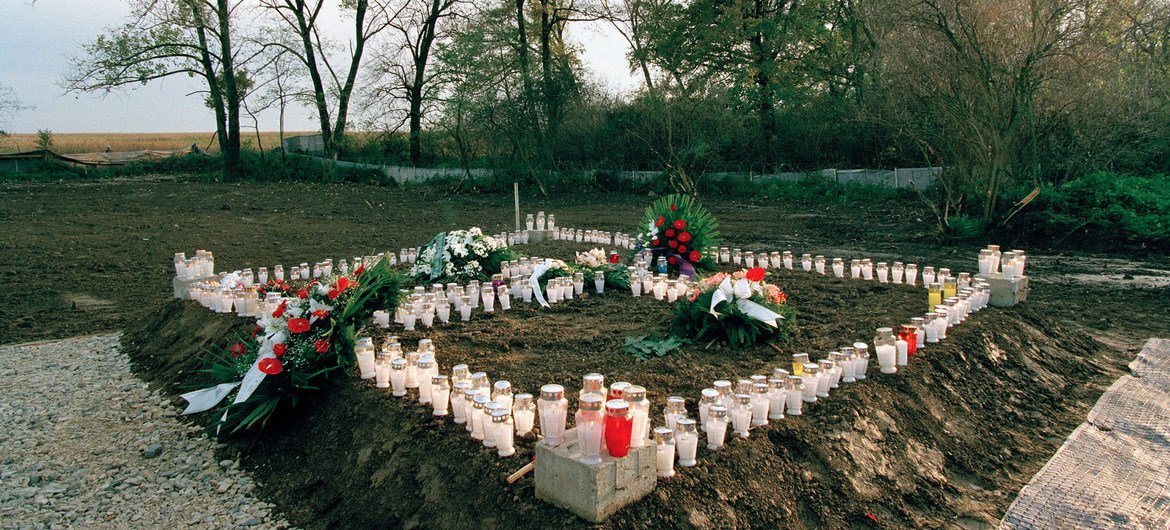 被蜡烛和花圈包围的克罗地亚奥夫卡拉的一个集体墓地。1994年，大约有200名平民在那里被屠杀。