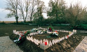 被蜡烛和花圈包围的克罗地亚奥夫卡拉的一个集体墓地。1994年，大约有200名平民在那里被屠杀。