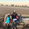 El redactor de Noticias ONU Abdelmonem Makki y sus sobrinos en la población en la que se crió en el sur de Darfur, en Sudán.
