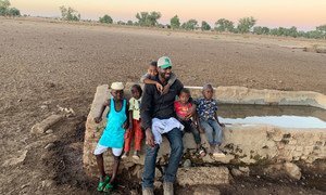 El redactor de Noticias ONU Abdelmonem Makki y sus sobrinos en la población en la que se crió en el sur de Darfur, en Sudán.