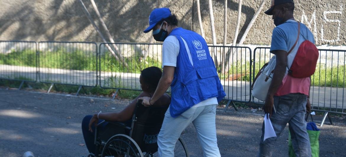 UNHCR staff assist a migrant at the Olympic Stadium in Tapachula, Chiapas, in November 2021.