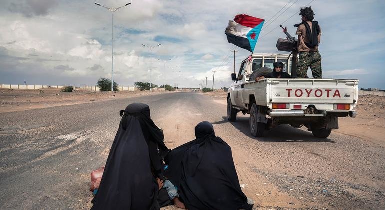 Soldados pasan al lado de dos mujeres limosneras en Lahj, Yemen.