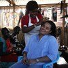 مبعوثة الأمين العام للشباب تقوم بتصفيف شعرها في إحدى الصالونات التي تديرها شابة من النازحات.