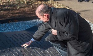 غريغوري غرين، الأخ التوأم لأندرو غرين، يلمس اسم شقيقه المدرج في النصب التذكاري لزلزال هايتي في مقر الأمم المتحدة، نيويورك.