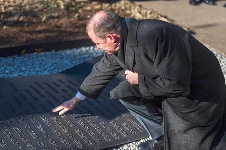 Gregory Grene, twin brother to Andrew Grene, touches the name of his brother inscribed in the Haiti earthquake memorial at UN Headquarters, New York.