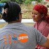 A UNFPA staff member speaks with a new mother cradling her child (not pictured), who were affected by the devastating 2015 earthquakes in Nepal. (file photo)