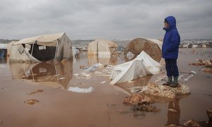 A child looks over a flooded area of Kafr Losin Camp in north-west Syria.