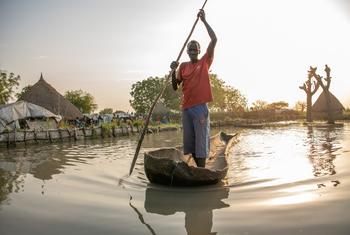 在南苏丹老凡卡克，一名因洪水而流离失所的农民在家中划着独木舟。