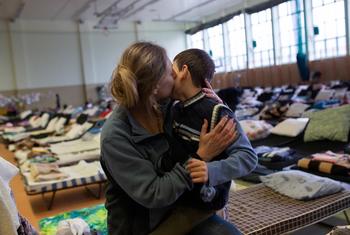 لاجئة من أوكرانيا تعانق ابنها في مركز استقبال أقيم في الصالة الرياضية في مدرسة في بلدة ميديكا الحدودية البولندية.
