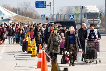 At the border crossing between Ukraine and Moldova at Palanca, refugees stand in line.