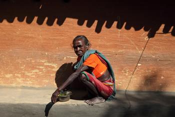 印度一位老妇人在阳光下吃午餐。酷热影响了这个国家的数亿人。