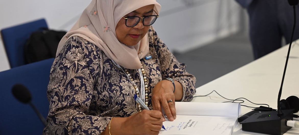 Maimunah Mohd Sharif, Executive Director of UN-Habitat, signs a copy of the World Cities Report 2022 at the World Urban Forum in Katowice, Poland.
