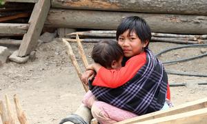 A child looks after his younger sibling in Myanmar.