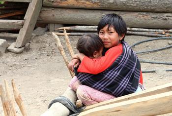 A child looks after his younger sibling in Myanmar.