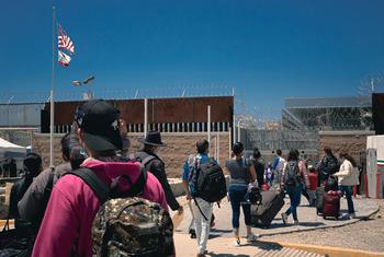 在墨西哥北部的蒂华纳，一群移民在国际移民组织工作人员陪同进入美国。（资料图片）