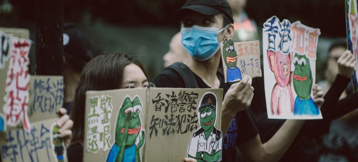 Hong Kong residents hold signs condemning police brutality during protests on August 31, 2019. 