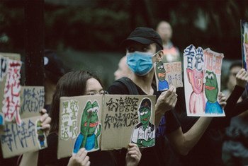 Hong Kong residents hold signs condemning police brutality during protests on August 31, 2019. 
