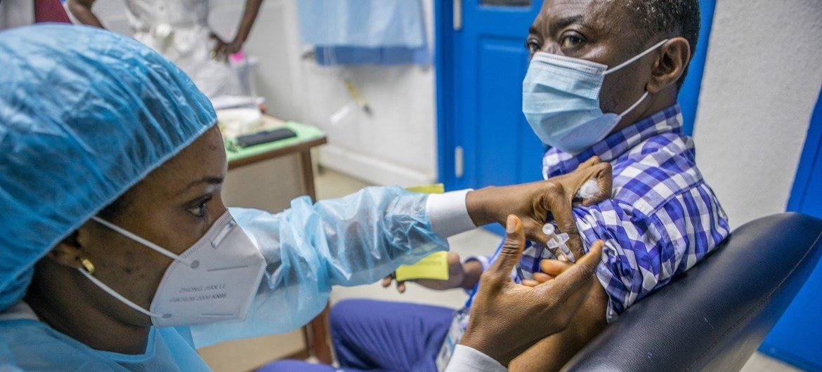 बेनिन में एक यूएन कर्मचारी को कोविड-19 वैक्सीन की ख़ुराक दी जा रही है. 