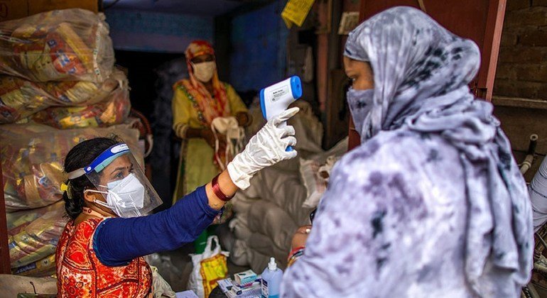 Vandana Gupta, trabajadora comunitaria de SEWA, comprueba la temperatura corporal como parte de los protocolos de seguridad de COVID-19 en un centro de distribución de raciones en Jahangir Puri, Nueva Delhi, India. Vandana Gupta, trabajadora comunitaria de SEWA, comprueba la temperatura corporal como parte de los protocolos de seguridad de COVID-19 en un centro de distribución de raciones en Jahangir Puri, Nueva Delhi, India.