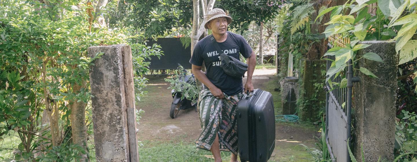 Dekha Dewandana porte les valises de ses invités de son gîte, le Esa di Kubu Homestay, situé dans le village de Sudaji, sur l'île indonésienne de Bali.