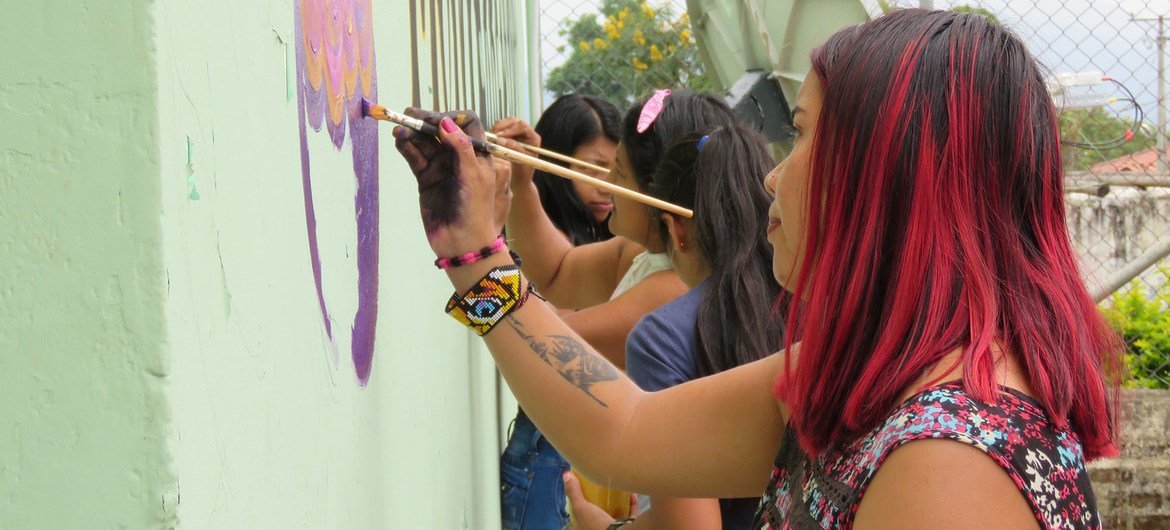 哥伦比亚中部蒙特雷东多（Monterredondo）的女性正在绘制和平主题的壁画。