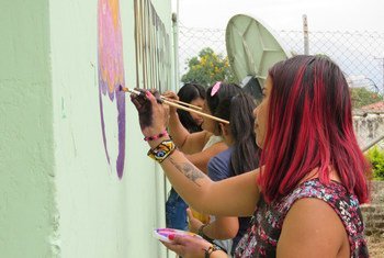 Mujeres colombianas decoran un muro con mensajes de paz.