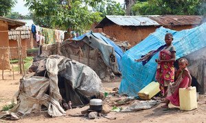 Members of the Mbuti indigenous community stand beside their shelters at a makeshift site for internally displaced persons in Beni territory, North Kivu.