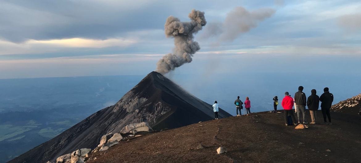 Tourists overlooking the erupting Fuego volcano from Acatenango volcano, Guatemala.
