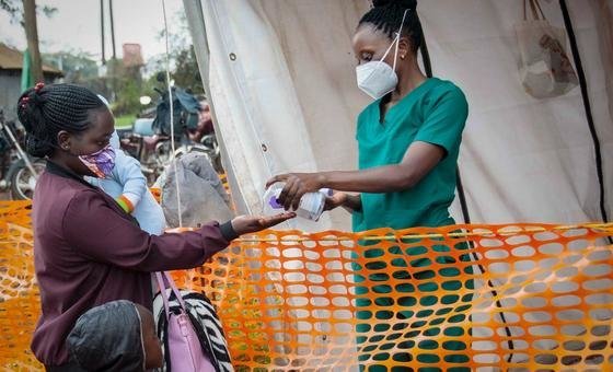 A nurse dispenses hand sanitizer to a visitor at a hospital in Masaka, Uganda.